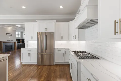 a kitchen with a refrigerator a sink and wooden floor