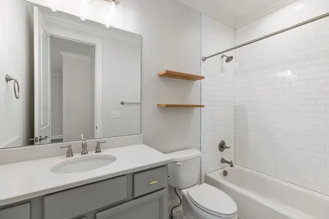 a bathroom with a sink toilet vanity and shower
