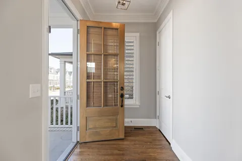 an entryway with wooden floor and a window