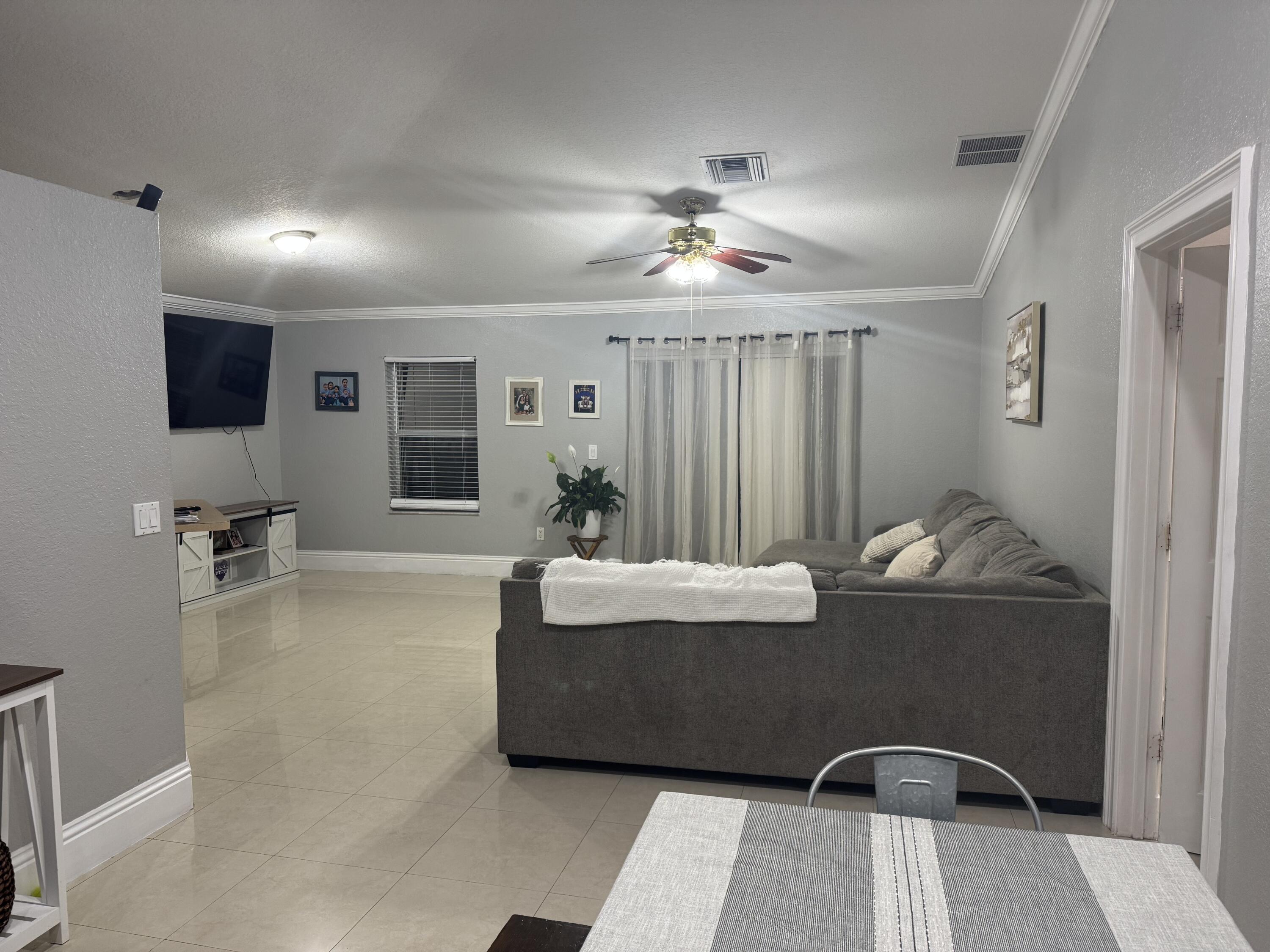 5621 Azalea Circle West Palm Beach, FL 33415 - Photo 13 of 20 a living room with furniture and a flat screen tv
