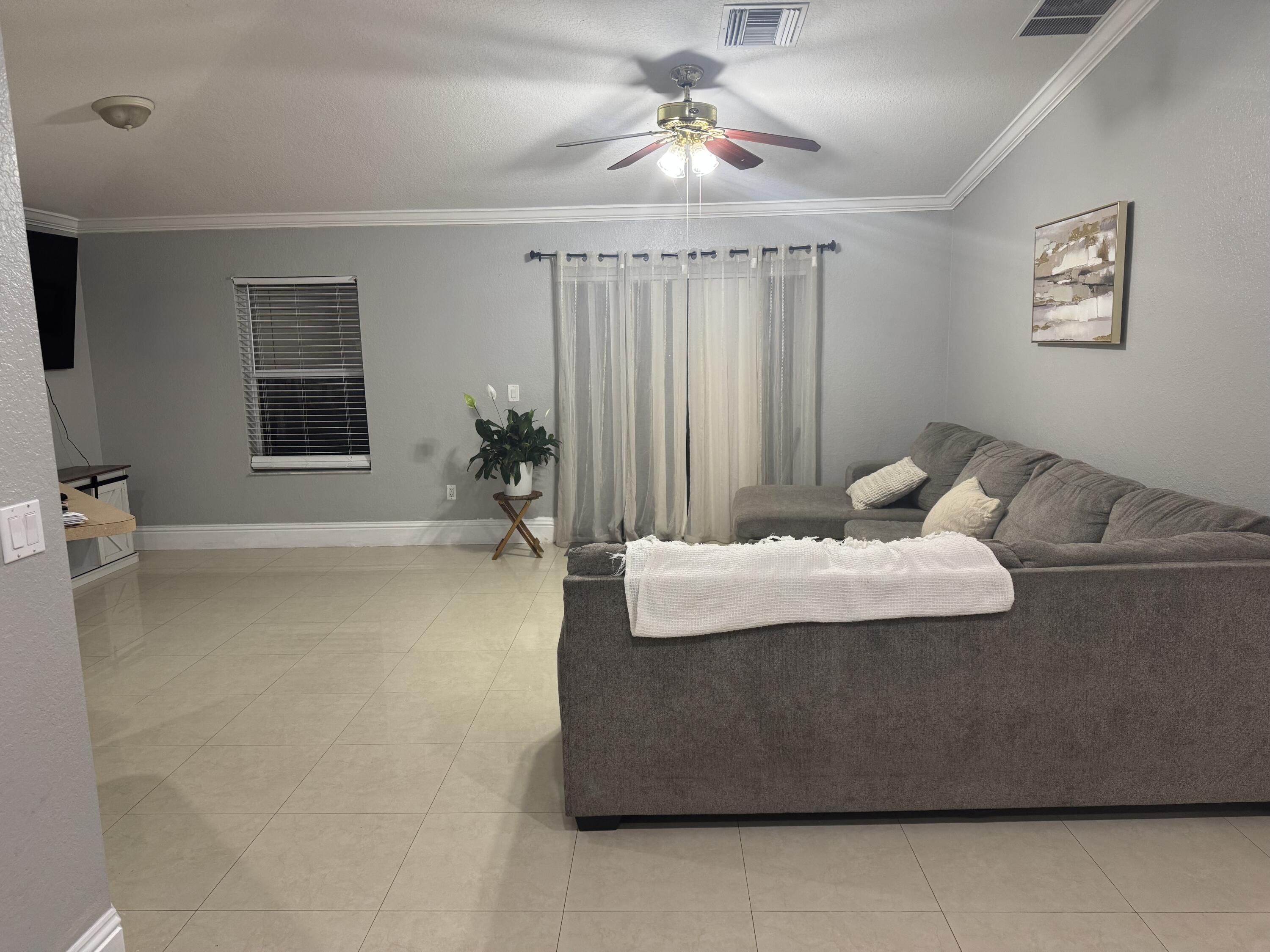 5621 Azalea Circle West Palm Beach, FL 33415 - Photo 14 of 20 a living room with furniture and a chandelier