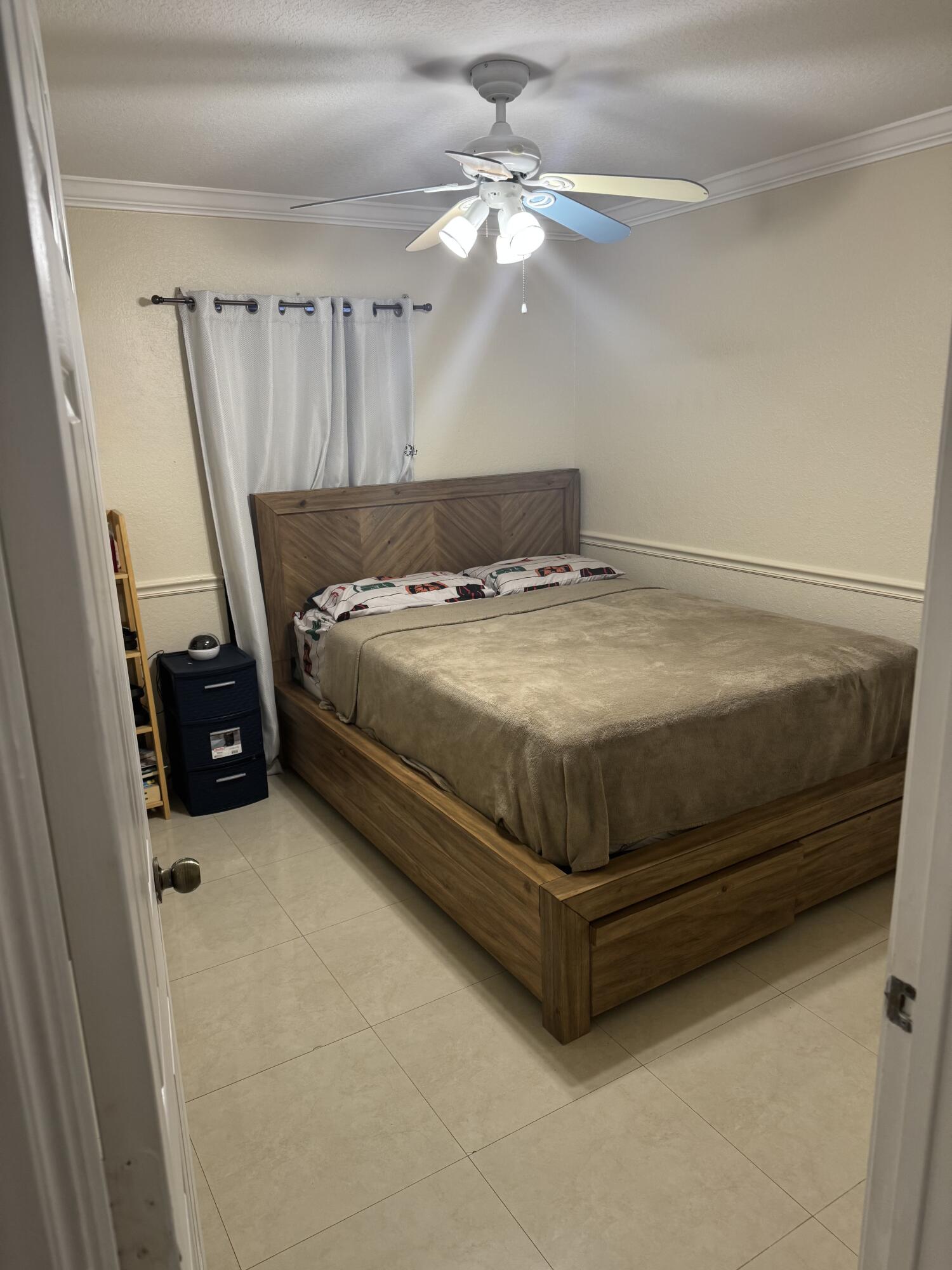 5621 Azalea Circle West Palm Beach, FL 33415 - Photo 19 of 20 a bedroom with a bed and a chandelier