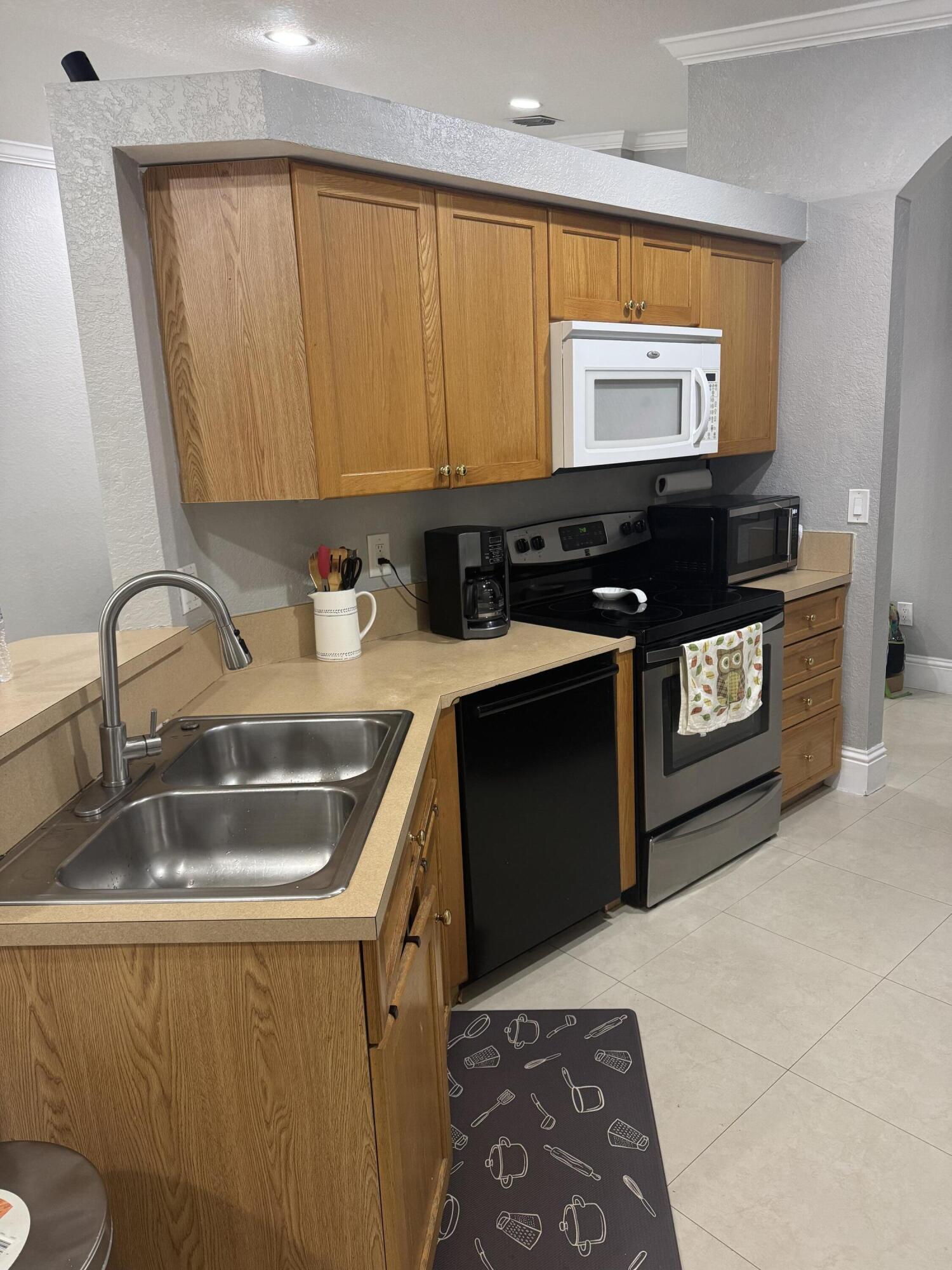 5621 Azalea Circle West Palm Beach, FL 33415 - Photo 3 of 20 a kitchen with a sink and a stove top oven