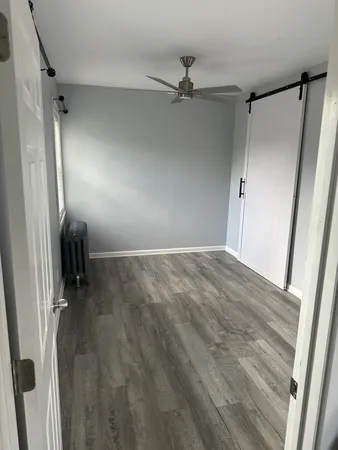 a view of a room with wooden floor and fan