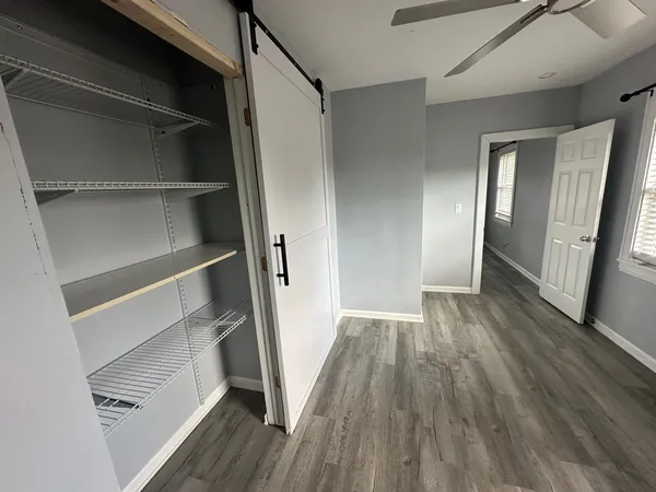 a view of walk in closet with wooden floor