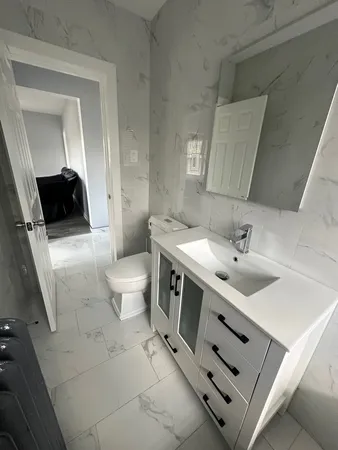 a spacious bathroom with a toilet sink and mirror