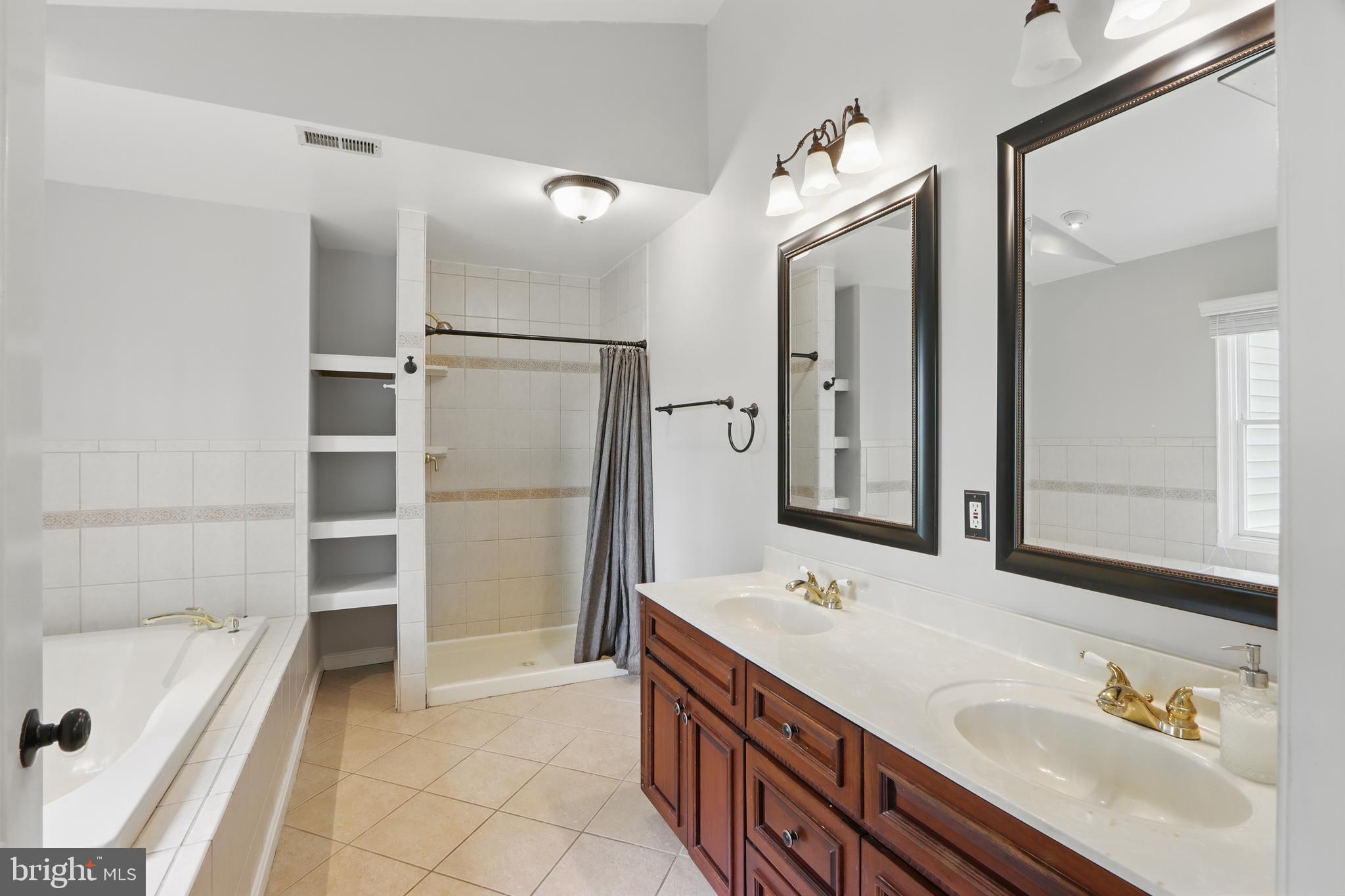 5185 Meadows Farm Road Lothian, MD 20711 - Photo 19 of 29 a bathroom with a tub a sink a mirror and a shower