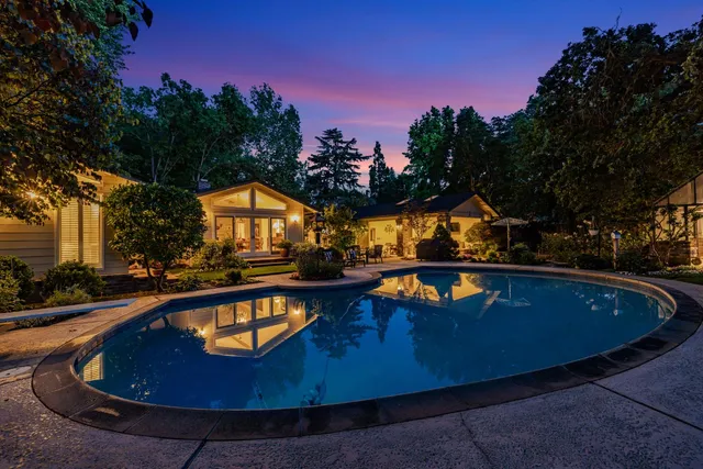 a view of swimming pool with outdoor seating and yard in the back