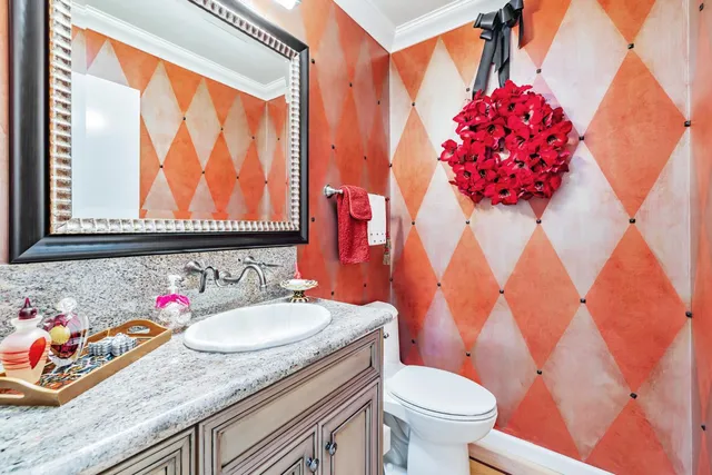 a bathroom with a granite countertop sink and a toilet