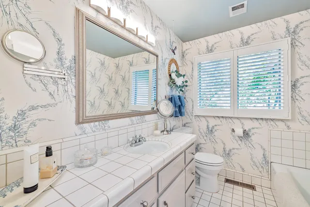 a bathroom with a sink a toilet and a window