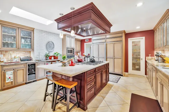 a kitchen with stainless steel appliances kitchen island granite countertop a sink and cabinets