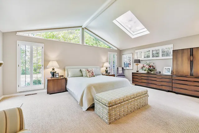 a spacious bedroom with a bed and a large window