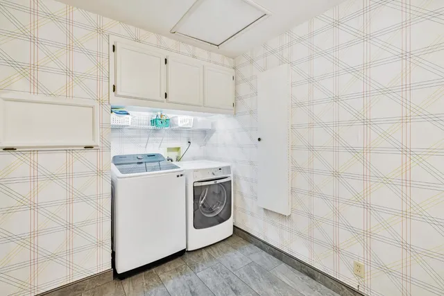 a utility room with cabinets washer and dryer