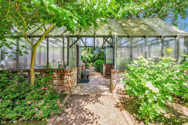 a backyard of a house with a garden and outdoor seating
