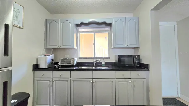 a kitchen with granite countertop white cabinets and a sink