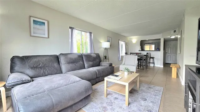 a living room with furniture wooden floor and a window