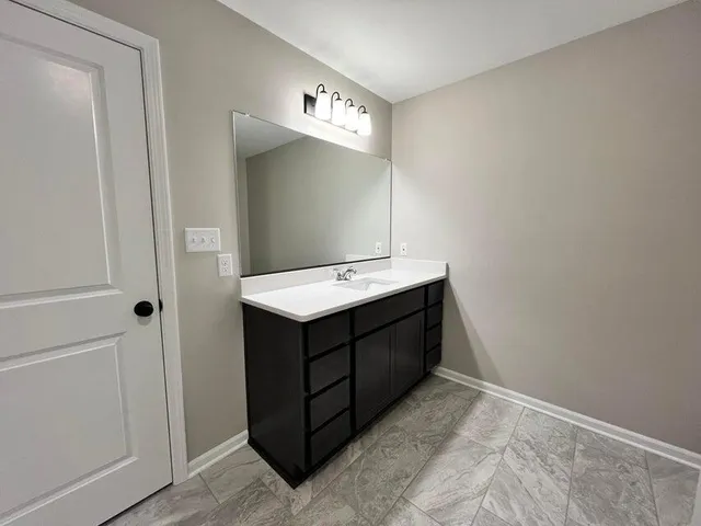 a bathroom with a sink vanity and mirror