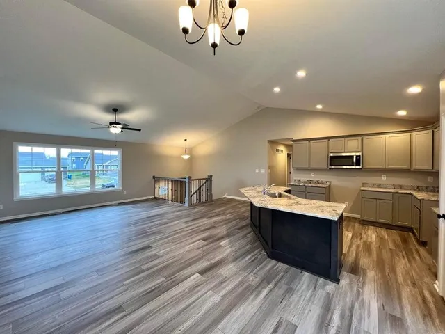 a kitchen with stainless steel appliances granite countertop a sink stove and wooden floor