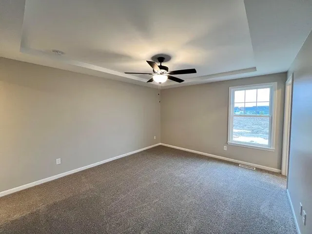 an empty room with a window and a ceiling fan