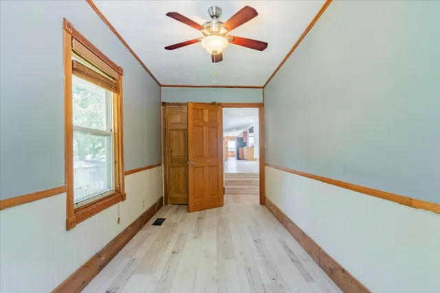 a view of hallway with wooden floor and chandelier