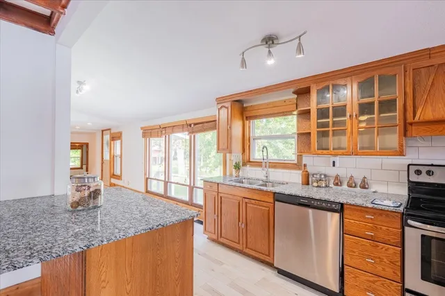 a kitchen with stainless steel appliances granite countertop a sink and a counter space