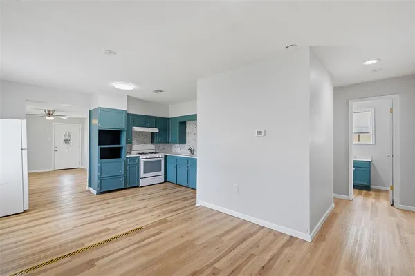 a kitchen with stainless steel appliances wooden floors and view living room