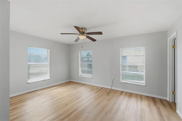 a view of a livingroom with a hardwood floor ceiling fan and window