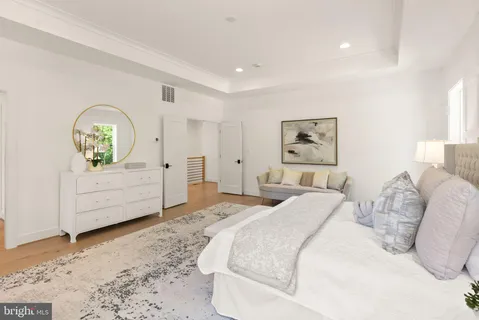 a spacious bedroom with a bed and a dresser