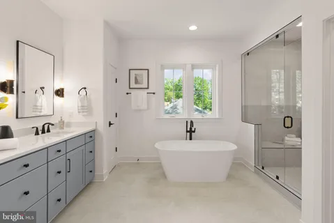 a spacious bathroom with a double vanity sink a mirror and a bathtub