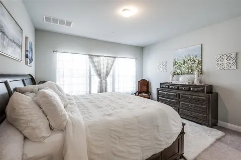 a bedroom with a bed and dresser with window