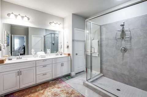 a bathroom with a double vanity sink toilet and shower