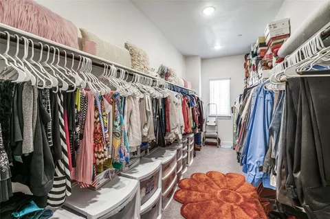 a view of walk in closet with clothes