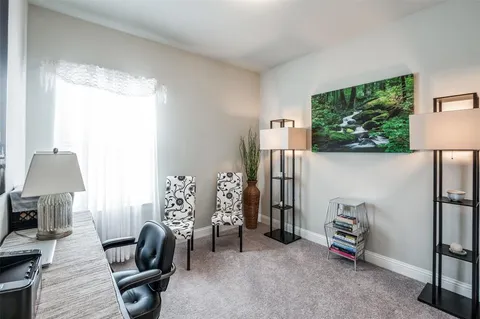 a view of a workspace with furniture and a window