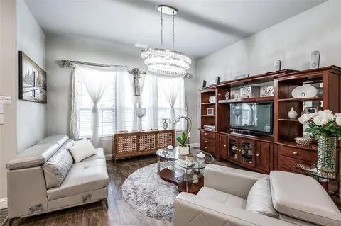 a living room with furniture a flat screen tv and a window