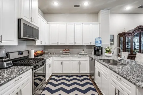 a kitchen with stainless steel appliances granite countertop a sink stove and cabinets