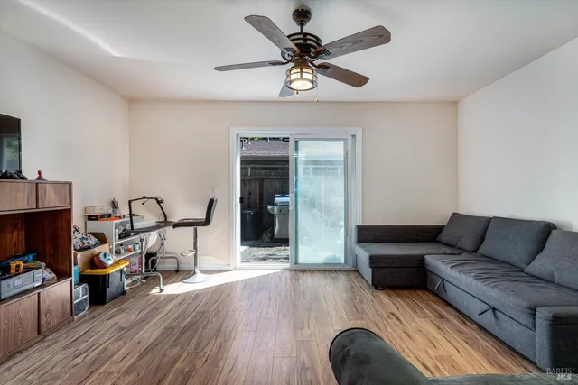 a view of a workspace with wooden floor and ceiling fan