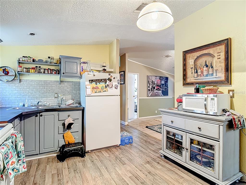 6421 Sunnyside Ranch Road Brooksville, FL 34602 - Photo 20 of 49 a view of a kitchen with fridge and wooden floor