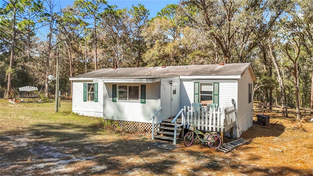 6421 Sunnyside Ranch Road Brooksville, FL 34602 - Photo 2 of 49 a view of a house with a yard and wooden fence
