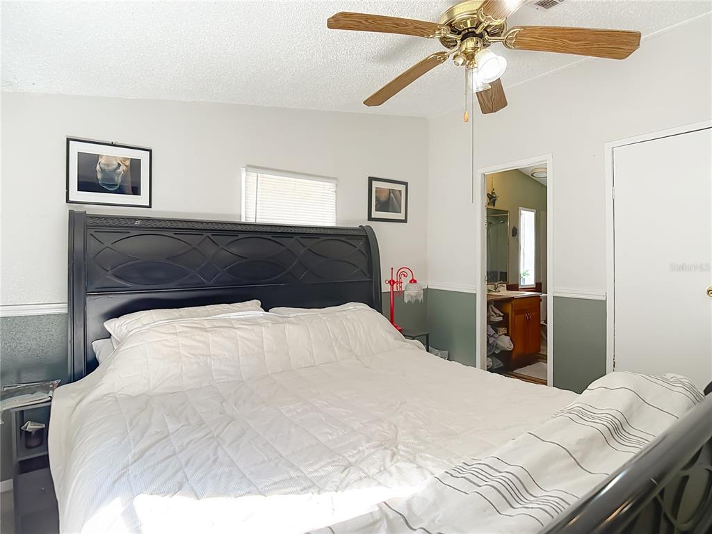 6421 Sunnyside Ranch Road Brooksville, FL 34602 - Photo 26 of 49 a bedroom with a bed and a chandelier