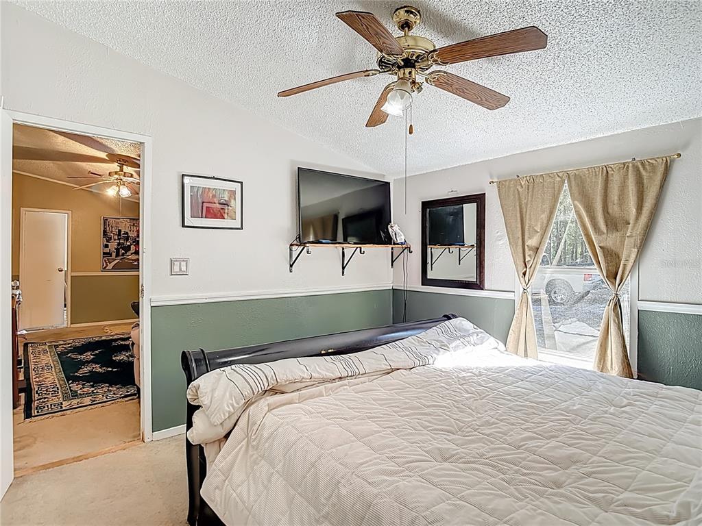 6421 Sunnyside Ranch Road Brooksville, FL 34602 - Photo 28 of 49 a bedroom with a large bed and a flat tv screen
