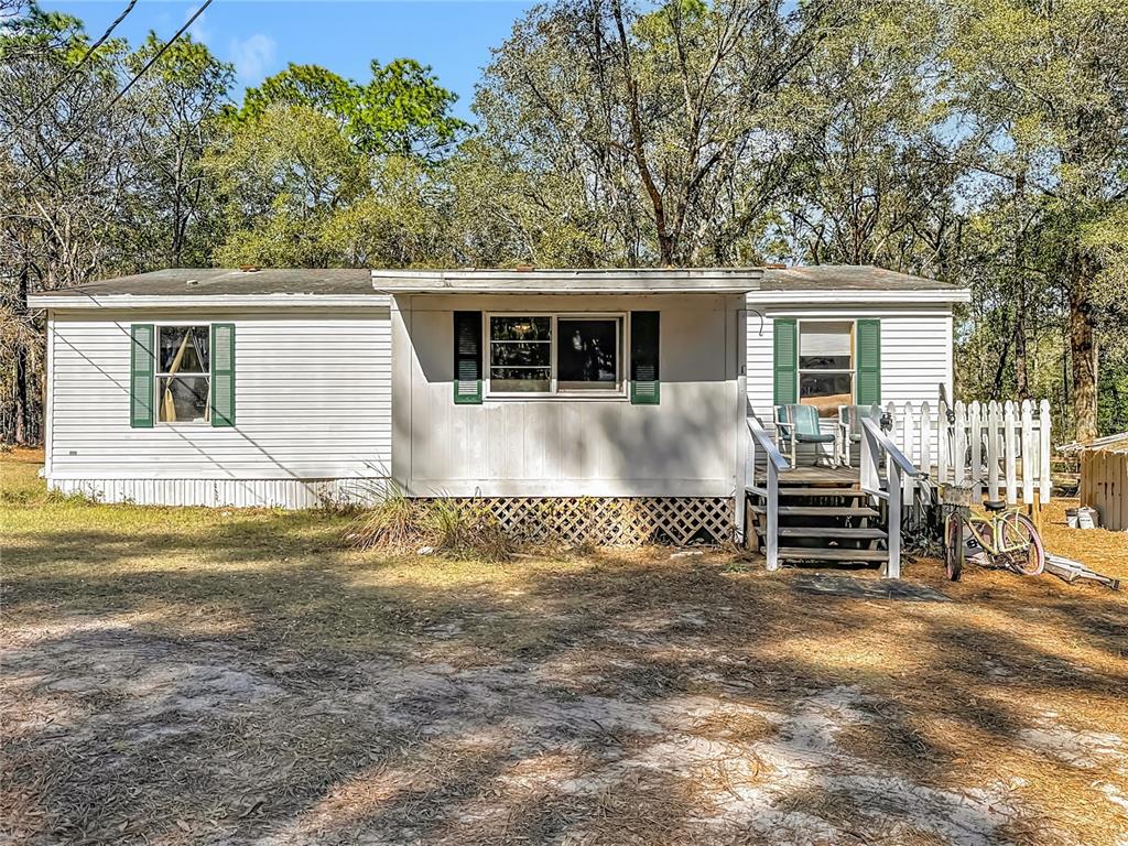 6421 Sunnyside Ranch Road Brooksville, FL 34602 - Photo 3 of 49 a view of house with backyard and trees