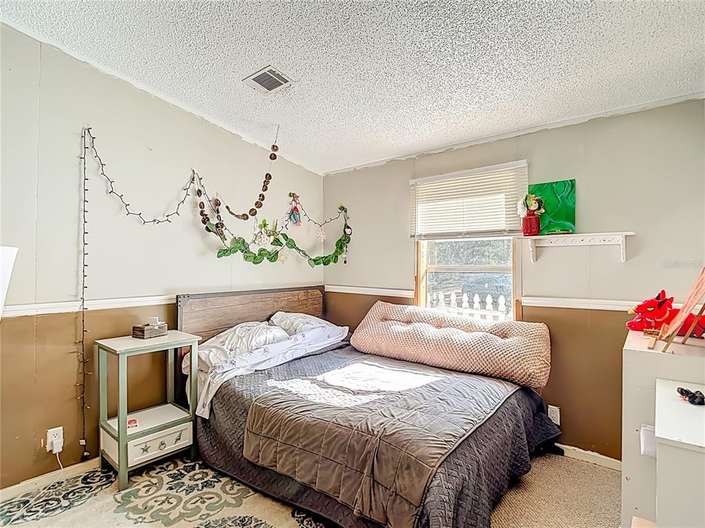 6421 Sunnyside Ranch Road Brooksville, FL 34602 - Photo 32 of 49 a bedroom with a bed and a couch