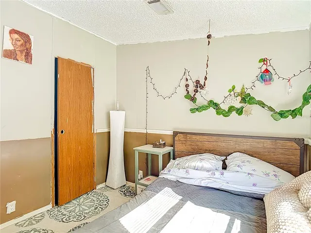 a bedroom with a bed and a wooden floor