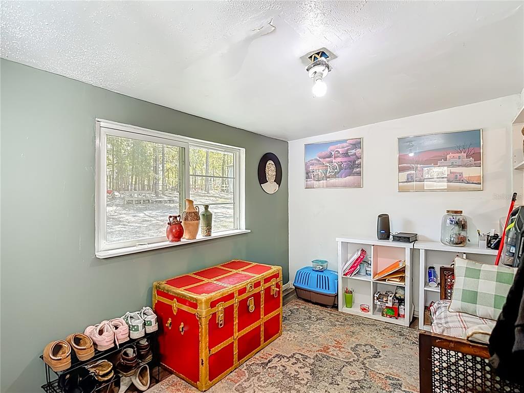 6421 Sunnyside Ranch Road Brooksville, FL 34602 - Photo 10 of 49 a living room with baby crib furniture and a window