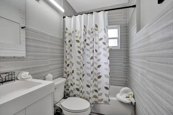 a bathroom with a sink a toilet and shower curtain