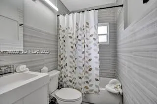 a bathroom with a toilet a sink and shower curtain