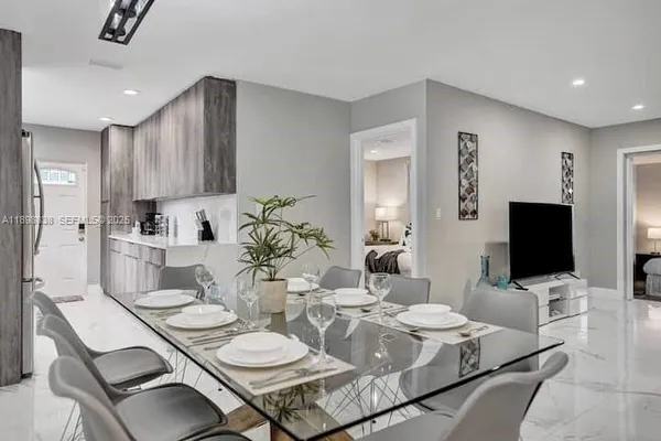 a dining room with furniture and a flat screen tv