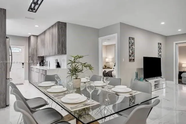 a dining room with furniture and a flat screen tv