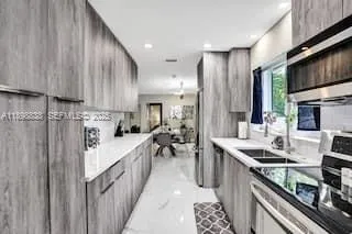a kitchen with stainless steel appliances sink stove microwave and cabinets