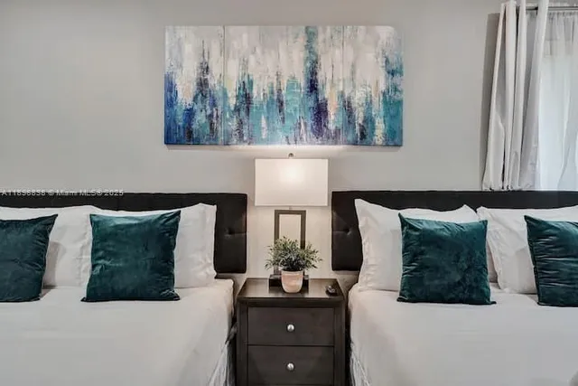 a bedroom with a bed and a lamp on dresser